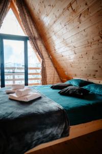 a bedroom with a bed and a large window at A Frame Panoramic Dundy in Dealu Muntelui