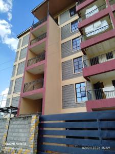 an apartment building with pink and purple balconies at Nanako Comforts in Kitengela 