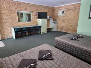 a hotel room with two beds and a table and chairs at Tiaro Motor Inn in Tiaro