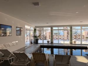 a room with a swimming pool with chairs and windows at A-Termal Palić in Palić