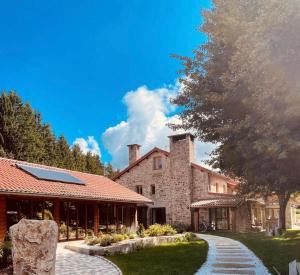 a large stone building with a tree in front of it at In Secreto in Dunières