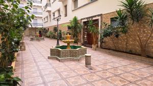 a fountain in the courtyard of a building at Abraj Dubai - Premium 3BR Stay in Heart of Larache in Larache