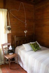 a bedroom with a bed and a wooden wall at The Hummingbird house, Costa Rica in Atenas