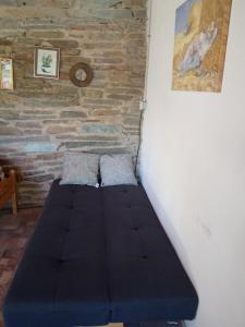 a bed in a room with a brick wall at Espacio de relax in Trapiche