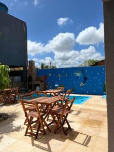 a group of tables and chairs next to a swimming pool at Pousada encantos de morro branco in Beberibe