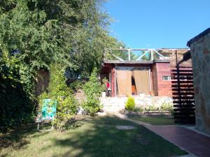 a garden with a building and a person in the background at Espacio de relax in Trapiche