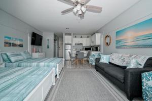 a bedroom with two beds and a couch at Cedar Key Islands Dolphins Cay Condo in Cedar Key