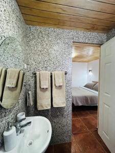 a bathroom with a sink and a bedroom with a bed at El Floramento in San Pedro de Atacama