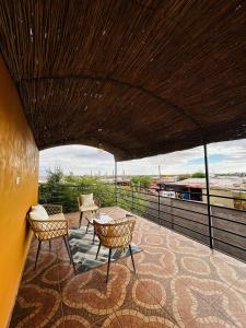 a patio with two chairs and a table on a roof at El Floramento in San Pedro de Atacama