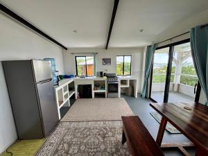 a kitchen with a stainless steel refrigerator and a table at Stella Mar Oceanfront Hotel in Popoyo