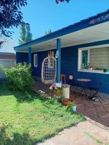 a blue house with a patio and a table at casa azul in Plottier