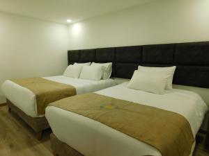 two beds sitting next to each other in a room at HOTEL MX BOGOTA in Bogotá +87 photos