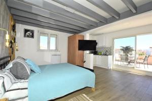 a bedroom with a blue bed and a balcony at les 2 dauphins in Le Barcarès
