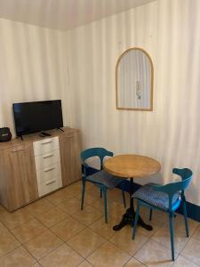 a room with a table and chairs and a tv at Studio centre ville in Nevers