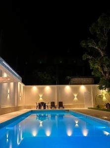 a swimming pool at night with a table and chairs at Valle Hermoso in San Ramón