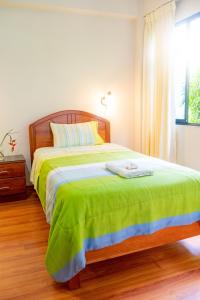 a bedroom with a large bed with a green blanket at Valle Hermoso in San Ramón