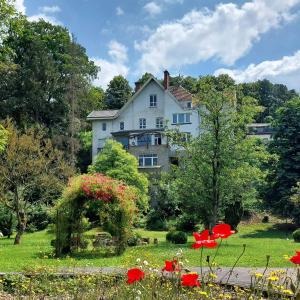 a large white house with flowers in the yard at Villa Belle Epoque L' atelier du temps B&B in Durbuy