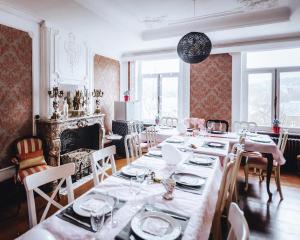 a dining room with tables and chairs and a fireplace at Villa Belle Epoque L' atelier du temps B&B in Durbuy