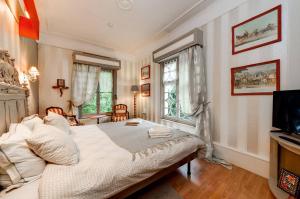 a bedroom with a bed and a television in it at Villa Belle Epoque L' atelier du temps B&B in Durbuy