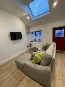 a living room with a couch and a flat screen tv at Howth Village Cottage in Howth