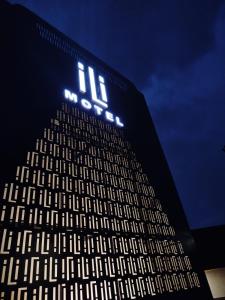 a tall building with a lit up sign on it at iLi Motel in Aparecida de Goiânia