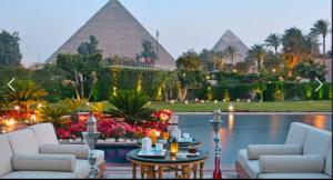 a living room with couches and a table and pyramids at Nubian oasis hotel in Aswan +44 photos
