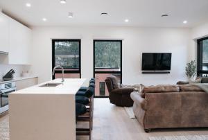 a kitchen and living room with a couch and a table at Cloudscape Penthouse by Revelstoke Vacations in Revelstoke