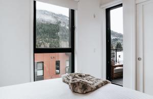 a bedroom with a bed and a large window at Cloudscape Penthouse by Revelstoke Vacations in Revelstoke