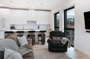 a living room with a couch and a kitchen at Cloudscape Penthouse by Revelstoke Vacations in Revelstoke