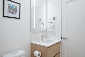 a white bathroom with a sink and a mirror at Cloudscape Penthouse by Revelstoke Vacations in Revelstoke +48 photos