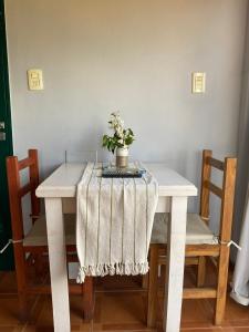 a white table with a vase of flowers on it at Annemarie Apart in Villa Paranacito