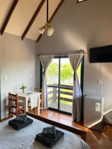 a bedroom with a bed and a table and a window at Annemarie Apart in Villa Paranacito