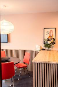 a dining room with red chairs and a table at Studio C with all you need in Wanaka