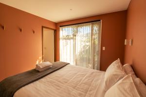 a bedroom with a bed with a large window at Studio C with all you need in Wanaka