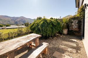 a wooden bench sitting outside of a building at Studio C with all you need in Wanaka
