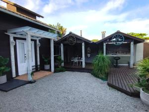 a house with a deck and a patio at Casa para temporada in Florianópolis