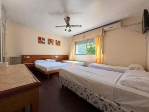 a bedroom with two beds and a ceiling fan at Hotel Aldeano ll in Buenos Aires