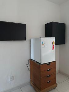 a white refrigerator sitting on top of a wooden dresser at El Laai Roi in Iguaba Grande