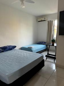 a bedroom with two beds and a table in it at El Laai Roi in Iguaba Grande