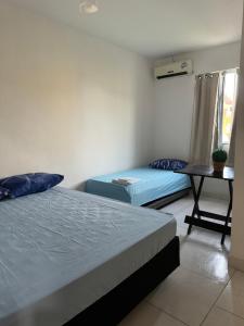 a room with two beds and a table with a desk at El Laai Roi in Iguaba Grande