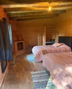 a bedroom with two beds and a fireplace at Cabanas Madre Tierra Zacatlan in Cedro