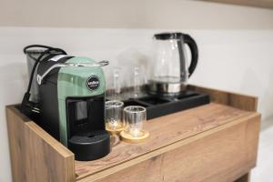 a coffee maker sitting on a wooden shelf with glasses at A Gallery Hotel in Shkodër