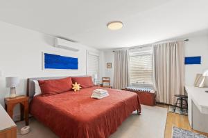 a bedroom with a red bed with a red blanket at West End Haven w/ Modern Kitchen + Private Yard in Provincetown