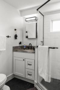 a white bathroom with a sink and a toilet at West End Haven w/ Modern Kitchen + Private Yard in Provincetown +39 photos