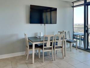 a dining room with a table and chairs and a television at Palisade Palms TW1012 - Sea Escape in Galveston