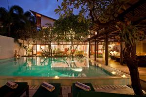 a swimming pool in the middle of a resort at Villa Casis by Nagisa Bali in Sanur