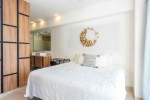 a bedroom with a white bed and a mirror at Life Bucerias in Bucerías +32 photos