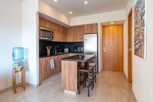 a kitchen with wooden cabinets and a black counter top at Life Bucerias in Bucerías