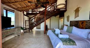 a living room with a large bed and a staircase at Spirit Holbox in Holbox Island