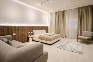 a bedroom with a bed and two chairs and a couch at A Gallery Hotel in Shkodër